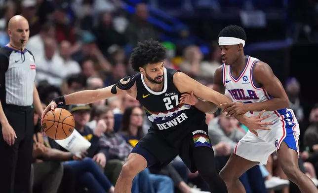Denver Nuggets guard Jamal Murray, left, looks to drive to the net as Philadelphia 76ers guard Vj Edgecombe defends in the first half of an NBA basketball game, Tuesday, March 17, 2026, in Denver. (AP Photo/David Zalubowski)