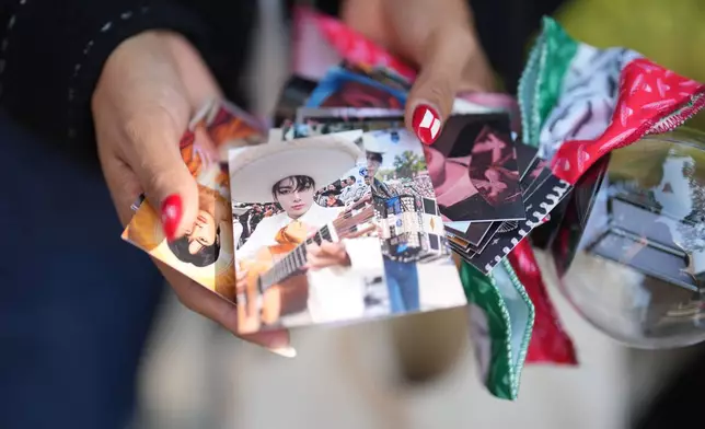 Aradith Gabriel from Mexico, a fan of K-pop band BTS, shows a photo of the BTS members, one of the goods and gifts she brought to exchange with fans from around the world ahead of the comeback concert of K-pop band BTS in Seoul, South Korea, Saturday, March 21, 2026. (AP Photo/Lee Jin-man)
