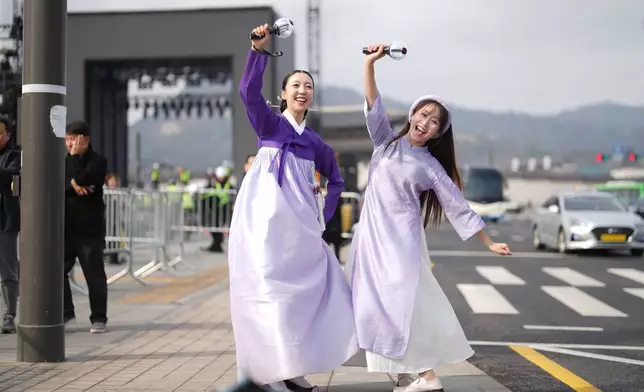 Fans of K-pop band BTS, South Korean Chaemin Shin, left, and Vietnamese Tam Tamie, right, and sing at Gwanghwamun Square in Seoul, South Korea, Wednesday, March 18, 2026. (AP Photo/Lee Jin-man)