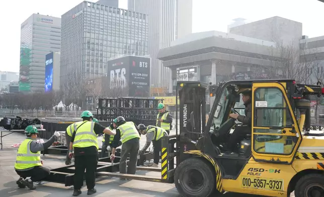Workers prepare for a concert by K-pop group BTS at Gwanghwamun Square in Seoul, South Korea, Monday, March 16, 2026. (AP Photo/Lee Jin-man)