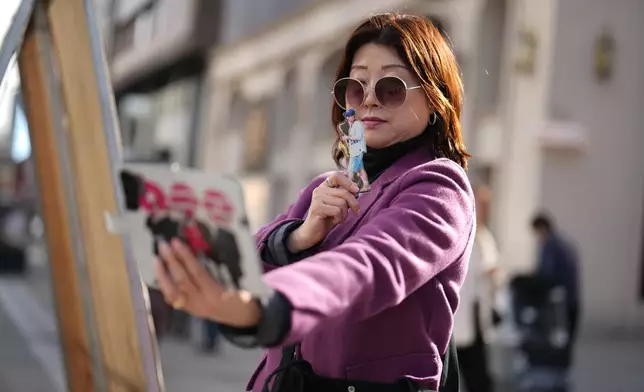 A fan of K-pop band BTS takes a selfie in downtown Seoul, South Korea, Thursday, March 19, 2026. (AP Photo/Lee Jin-man)