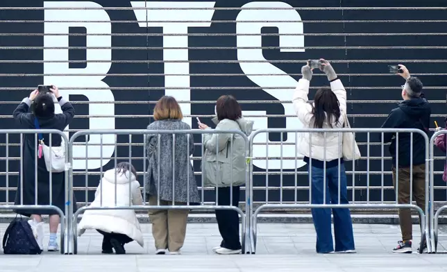 Fan of K-pop band BTS in front of a logo of BTS in Seoul, South Korea, Monday, March 16, 2026. (AP Photo/Lee Jin-man)