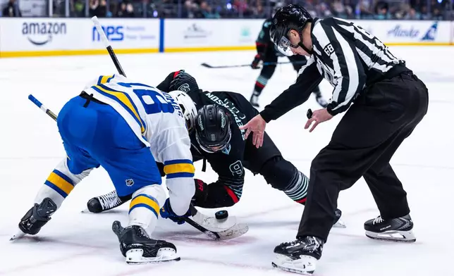 St. Louis Blues center Robert Thomas (18) faces off against Seattle Kraken center Chandler Stephenson (9) during the third period of an NHL hockey game Wednesday, March 4, 2026, in Seattle. (AP Photo/Maddy Grassy)