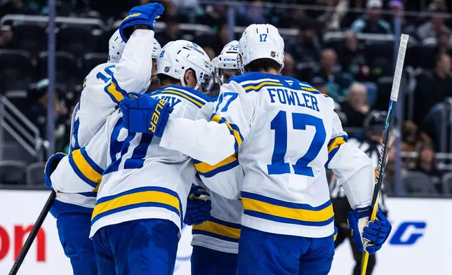 St. Louis Blues left wing Dylan Holloway (81) and defenseman Cam Fowler (17) celebrate with teammates after goal by Holloway and an assist to Fowler during the second period an NHL hockey game against the Seattle Kraken, Wednesday, March 4, 2026, in Seattle. (AP Photo/Maddy Grassy)