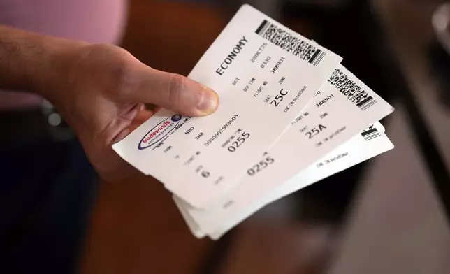 A Palestinian man who traveled to South Africa via a charter flight organized by an Israeli group whose founder supported U.S. President Donald Trump's proposal to resettle Palestinians from Gaza, shows his boarding passes in his temporary flat in Johannesburg, South Africa, Wednesday, Feb. 4, 2026. (AP Photo/Jerome Delay)