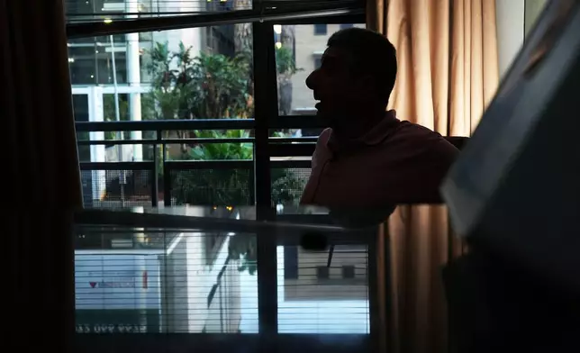 A Palestinian man who traveled to South Africa via a charter flight organized by an Israeli group whose founder supported U.S. President Donald Trump's proposal to resettle Palestinians from Gaza sits in his temporary flat in Johannesburg, South Africa, Wednesday, Feb. 4, 2026. (AP Photo/Jerome Delay)