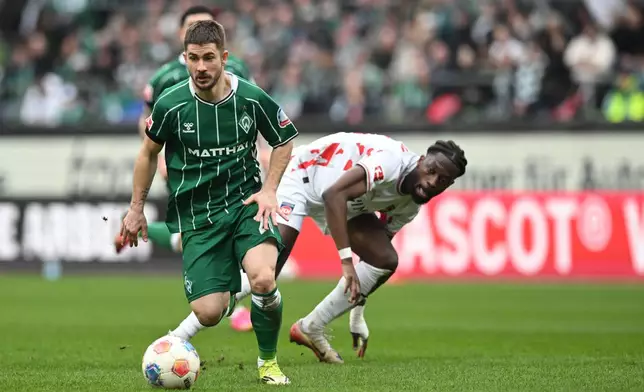 Werder's Romano Schmid, left, fights for the ball against Heidenheim's Omar Traore during the German Bundesliga soccer match between Werder Bremen and 1. FC Heidenheim, in Bremen, Germany, Saturday, Feb. 28, 2026. (Carmen Jaspersen/dpa via AP)