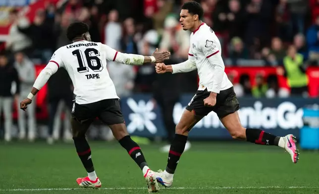 Bayer's Jarell Quansah, right, celebrates with Axel Tape after scoring his side's first goal during the German Bundesliga soccer match between Bayer Leverkusen and FSV Mainz 05, in Leverkusen, Germany, Saturday, Feb. 28, 2026. (Marius Becker/dpa via AP)