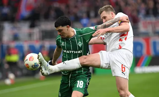 Werder's Cameron Puertas Castro, left, fights for the ball against Heidenheim's Patrick Mainka during the German Bundesliga soccer match between Werder Bremen and 1. FC Heidenheim, in Bremen, Germany, Saturday, Feb. 28, 2026. (Carmen Jaspersen/dpa via AP)