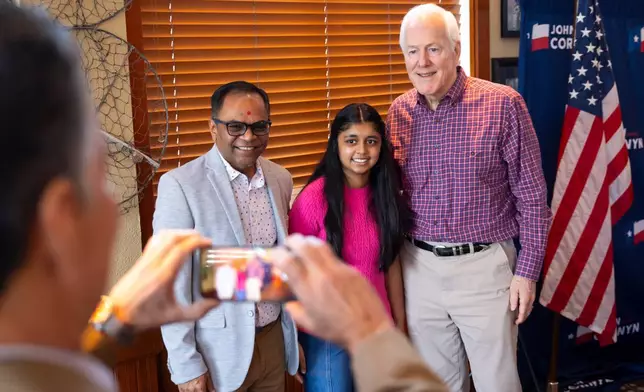 Kalpesh Patel and his 12-year-old daughter Keya pose for a photo with Sen. John Cornyn, R-Texas, during a campaign stop in The Woodlands, Texas, Saturday, Feb. 28, 2026. Keya recently completed a project on Cornyn for her seventh grade Texas history class. (AP Photo/Annie Mulligan)