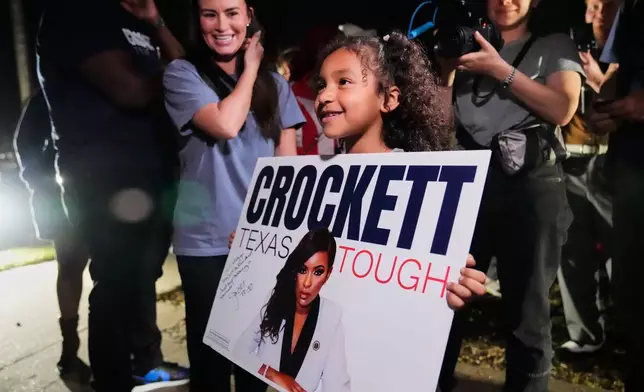 Cataleya Davis holds a poster promoting primary candidate for U.S. Senate Rep. Jasmine Crockett, D-Texas, during a campaign stop in Dallas, Friday, Feb. 27, 2026. (AP Photo/Tony Gutierrez)