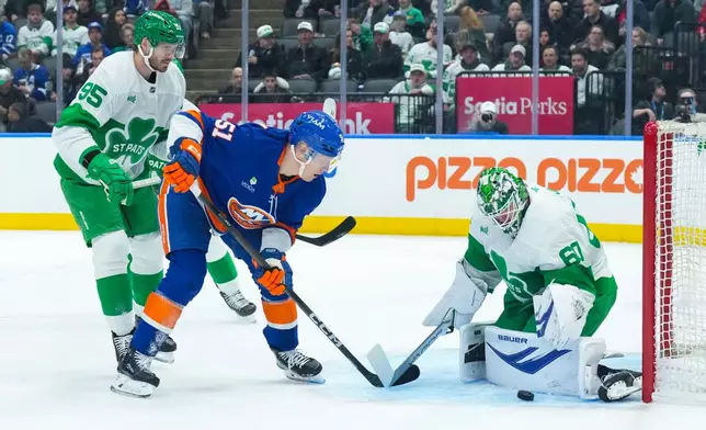 New York Islanders' Emil Heineman, center, shoots on Toronto Maple Leafs goaltender Joseph Woll during the first period of an NHL hockey game in Toronto, Tuesday March 17, 2026. (Chris Young/The Canadian Press via AP)