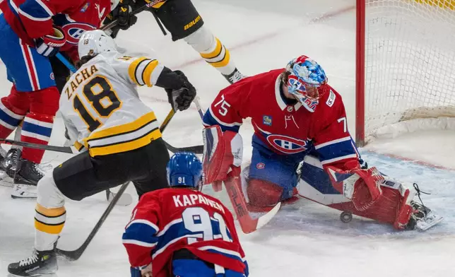 Montreal Canadiens goaltender Jakub Dobes (75) looks for the puck on a shot by Boston Bruins' Pavel Zacha (18) during the first period of an NHL hockey game in Montreal, Tuesday, March 17, 2026. (Christinne Muschi/The Canadian Press via AP)