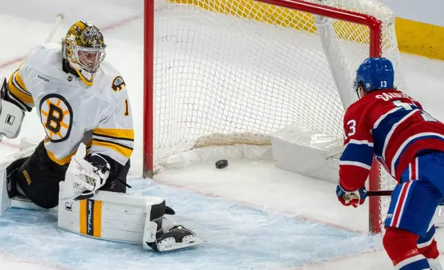 Montreal Canadiens' Cole Caufield (13) scores on Boston Bruins goaltender Jeremy Swayman (1) during overtime NHL hockey action in Montreal on Tuesday, March 17, 2026. (Christinne Muschi/The Canadian Press via AP)