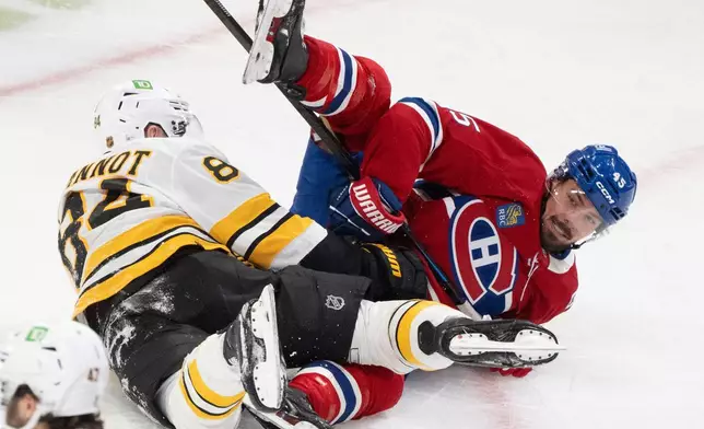 Montreal Canadiens' Alexandre Carrier (45) and Boston Bruins' Tanner Jeannot (84) get tangled up during second period NHL hockey action in Montreal, on Tuesday, March 17, 2026. (Christinne Muschi/The Canadian Press via AP)
