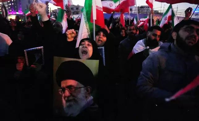Government supporters chant slogans as they gather in mourning after state TV officially announced the death of Iranian Supreme Leader Ayatollah Ali Khamenei, shown in the poster, in Tehran, Iran, Sunday, March 1, 2026. (AP Photo/Vahid Salemi)