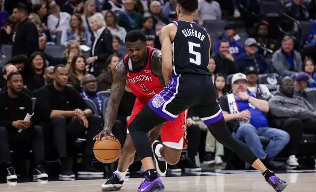New Orleans Pelicans forward Zion Williamson (1) attempts to dribble past Sacramento Kings guard Nique Clifford (5) before being called for an offensive foul during the first half of an NBA basketball game Thursday, March 5, 2026, in Sacramento, Calif. (AP Photo/Scott Marshall)