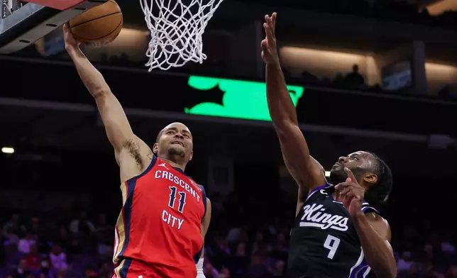 New Orleans Pelicans guard Bryce McGowens (11) prepares to dunk the ball over Sacramento Kings forward Precious Achiuwa (9) during the first half of an NBA basketball game Thursday, March 5, 2026, in Sacramento, Calif. (AP Photo/Scott Marshall)