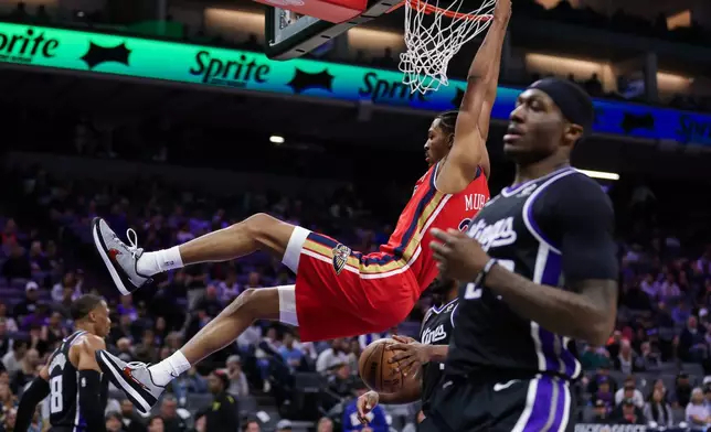 New Orleans Pelicans forward Trey Murphy III (25) hangs on the rim after dunking the ball against the Sacramento Kings during the first half of an NBA basketball game Thursday, March 5, 2026, in Sacramento, Calif. (AP Photo/Scott Marshall)