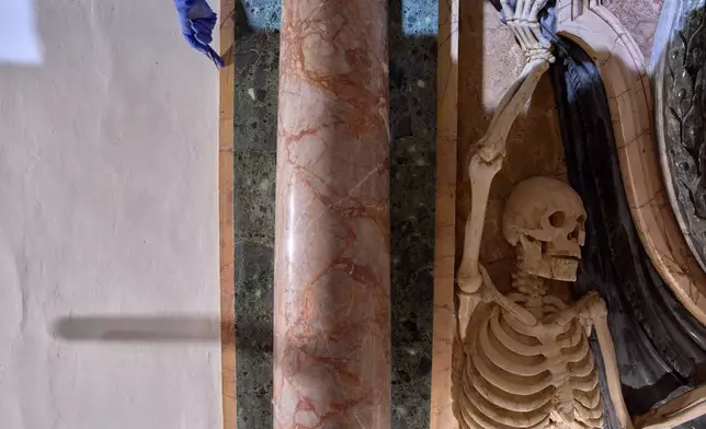The hand of a restorer peaks from a scaffolding inside the Basilica of San Pietro in Vincoli in Rome, Monday, March 9, 2026. (AP Photo/Domenico Stinellis)