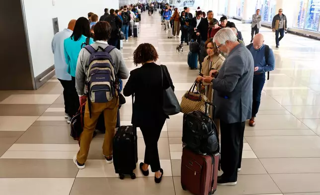 Passengers stand in the TSA pre-check line at LaGuardia Airport, Thursday, March 26, 2026, in New York. (AP Photo/Noah K. Murray)