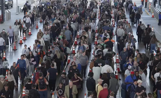 Travelers line up at a TSA checkpoint at George Bush Intercontinental Airport in Houston, Thursday, March 26, 2026. (AP Photo/Lekan Oyekanmi)