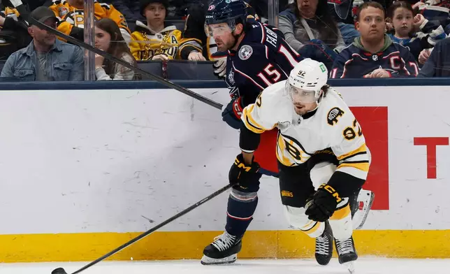 Columbus Blue Jackets' Dante Fabbro, left, and Boston Bruins' Marat Khusnutdinov chase the puck during the second period of an NHL hockey game, Sunday, March 29, 2026, in Columbus, Ohio. (AP Photo/Jay LaPrete)
