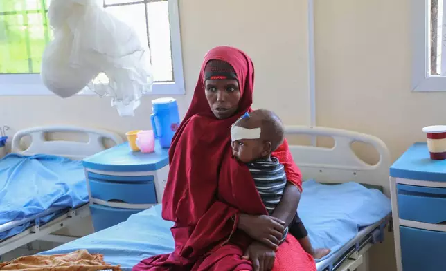Isho Isak sits with her malnourished child at Dolow Referral Hospital in southern Somalia after being affected by drought, Wednesday, March 25, 2026 (AP Photo/Mohamed Sheikh Nor)