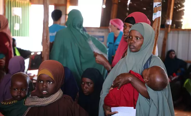 A Somali mother holds her malnourished child as she waits to receive therapeutic food at a UNICEF-funded nutrition center in Dolow, Somalia, Wednesday, March 25, 2026. (AP Photo/Mohamed Sheikh Nor)