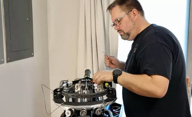Digital imaging technician Chris Ratledge strings a tennis racket at his home in Peachtree City, Ga., Thursday, March 5, 2026. (AP Photo/R.J. Rico)