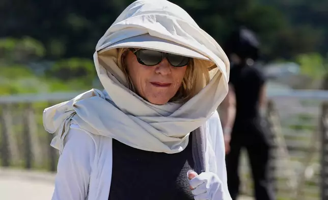 Carol Hather wears sun protective gear as she walks at Crissy Field in San Francisco, Tuesday, March 17, 2026. (AP Photo/Godofredo A. Vásquez)