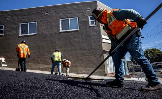New roadway material is spread out as a paving crew with McGuire &amp; Hester lays new asphalt, as temperatures in the bay area began to climb in Oakland, Calif., on Monday, March 16, 2026. (Carlos Avila Gonzalez/San Francisco Chronicle via AP)