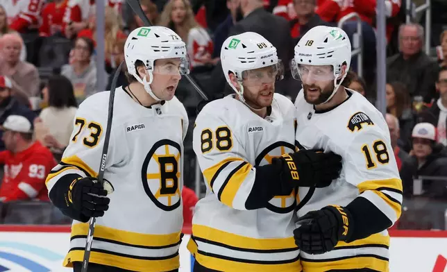 Boston Bruins right wing David Pastrnak (88) celebrates after his goal against the Detroit Red Wings with defenseman Charlie McAvoy (73) and center Pavel Zacha (18) during the second period of an NHL hockey game Saturday, March 21, 2026, in Detroit. (AP Photo/Duane Burleson)
