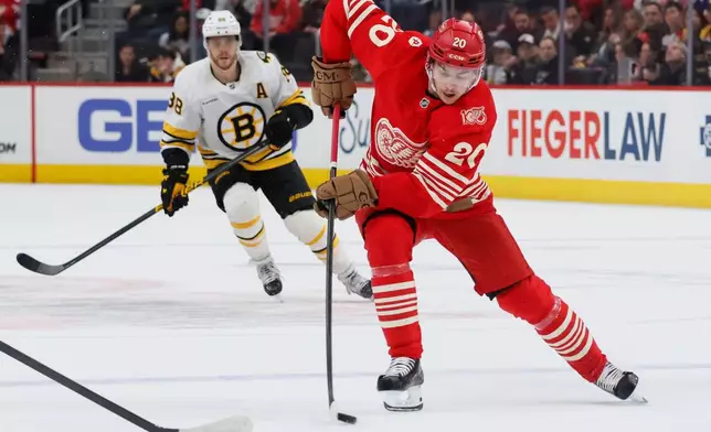 Detroit Red Wings defenseman Albert Johansson (20) is pursued by Boston Bruins right wing David Pastrnak (88) while skating toward the goal during the first period of an NHL hockey game Saturday, March 21, 2026, in Detroit. (AP Photo/Duane Burleson)