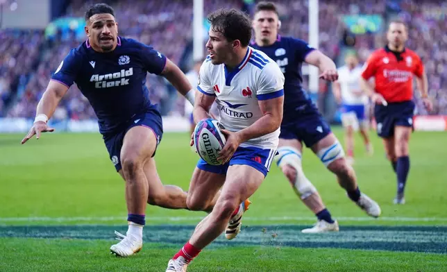 France's Antoine Dupont and Scotland's Sione Tuipulotu, left, in action during the Six Nations rugby match between Scotland and France in Edinburgh, Scotland, Saturday March 7, 2026. (Jane Barlow/PA via AP)