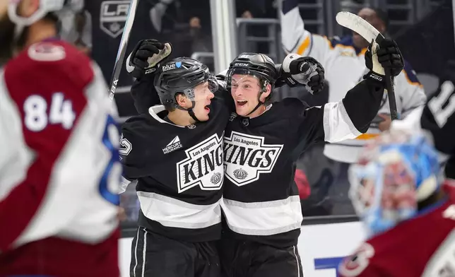 Los Angeles Kings defenseman Angus Booth, right, celebrates with left wing Artemi Panarin after scoring his first career goal during the second period of an NHL hockey game against the Colorado Avalanche Monday, March 2, 2026 in Los Angeles. (AP Photo/Ryan Sun)