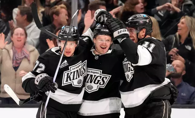 Los Angeles Kings defenseman Mikey Anderson, center, celebrates his goal with left wing Artemi Panarin, left, and center Anze Kopitar during the second period of an NHL hockey game against the New York Islanders, Thursday, March 5, 2026, in Los Angeles. (AP Photo/Mark J. Terrill)