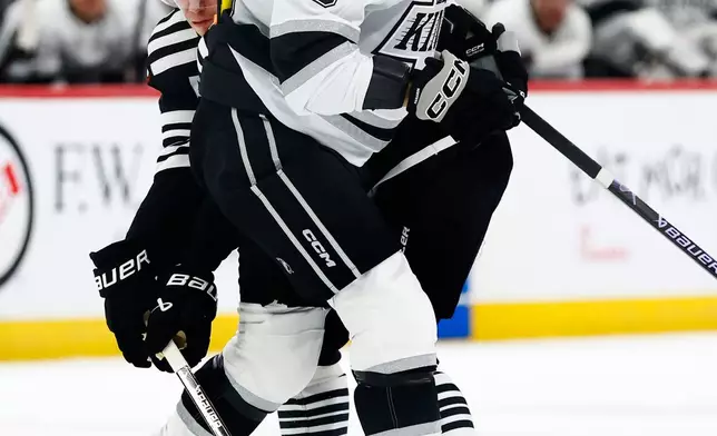 Los Angeles Kings left wing Artemi Panarin (10) collides with New Jersey Devils center Jack Hughes (86) playing the puck during the second period of an NHL hockey game, Saturday, March 14, 2026, in Newark, N.J. (AP Photo/Noah K. Murray)