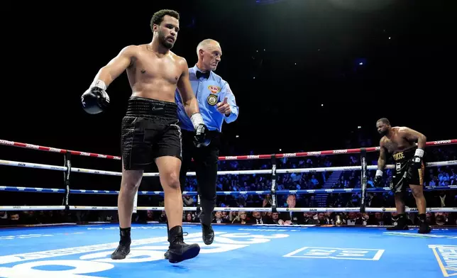 Boxer Moses Itauma, left, is directed to a corner after knocking down Jermaine Franklin during a WBA International and WBO Inter-Continental Heavyweight bout against Jermaine Franklin, Saturday, March 28, 2026, in Manchester, England. (Nick Potts/PA via AP)