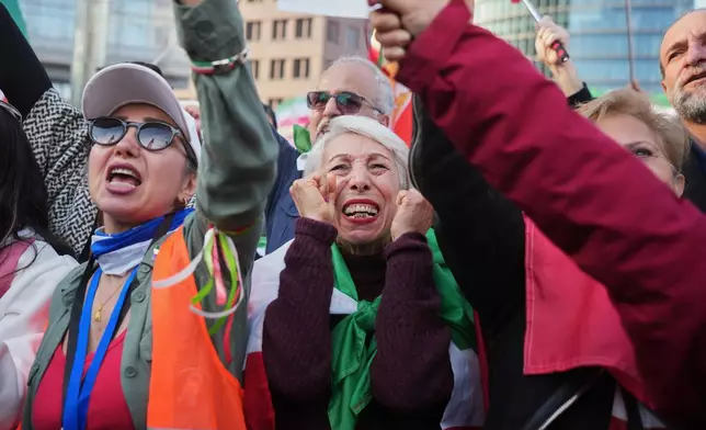 Iranian people attend a demonstration in support of the U.S. and Israeli strikes on Iran, in Berlin, Germany, Saturday, Feb. 28, 2026. (AP Photo/Markus Schreiber)