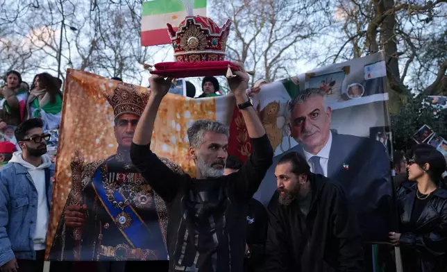 A protester holds a crown in London, Saturday, Feb. 28, 2026 after U.S. and Israeli forces carried out a series of strikes on Iran on Saturday morning. (AP Photo/Alastair Grant)