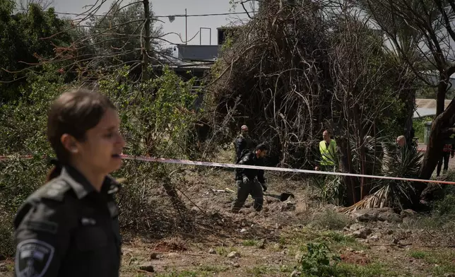 Israeli security forces inspect the site struck by an Iranian missile in central Israel, Thursday, March 5, 2026. (AP Photo/Leo Correa)