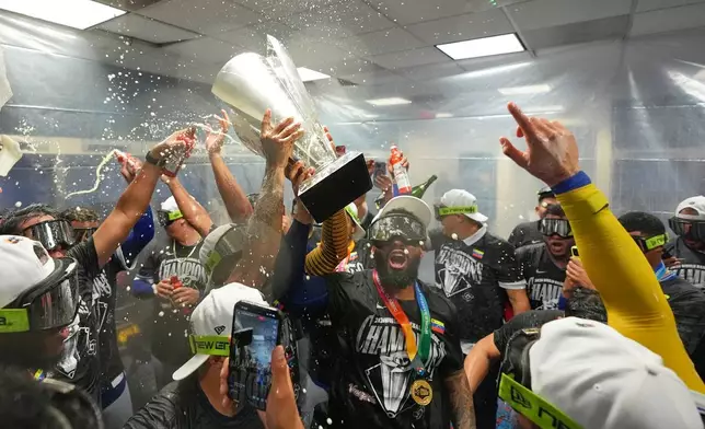 The Venezuela team celebrate with the trophy after defeating the United States in the championship game of the World Baseball Classic, Tuesday, March 17, 2026, in Miami. (AP Photo/Rebecca Blackwell)