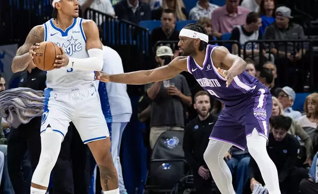 Orlando Magic forward Paolo Banchero (5) holds the ball against Sacramento Kings forward Precious Achiuwa (9) during the first half of an NBA basketball game, Thursday, March 26, 2026, in Orlando, Fla. (AP Photo/Willie J. Allen Jr.)