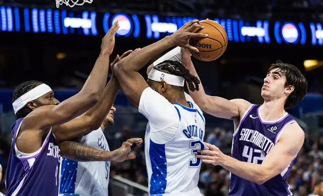 Orlando Magic center/forward Wendell Carter Jr. (34) fights for the ball with Sacramento Kings center Maxime Raynaud (42) during the first half of an NBA basketball game, Thursday, March 26, 2026, in Orlando, Fla. (AP Photo/Willie J. Allen Jr.)