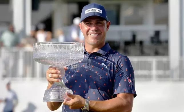 Gary Woodland holds the championship trophy after winning the Texas Children's Houston Open golf tournament Sunday, March 29, 2026, in Houston. (AP Photo/Michael Wyke)