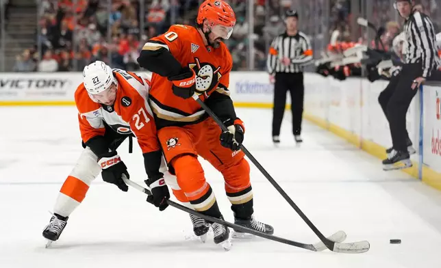 Philadelphia Flyers left wing Noah Cates, left, reaches in on Anaheim Ducks left wing Chris Kreider during the first period of an NHL hockey game Wednesday, March 18, 2026, in Anaheim, Calif. (AP Photo/Mark J. Terrill)