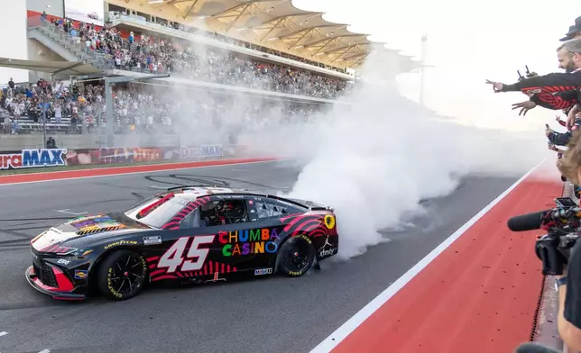 23XI Racing's Tyler Reddick celebrates his win with his team members during a NASCAR Cup Series auto race in Austin, Texas, Sunday, March 1, 2026. (AP Photo/Stephen Spillman)