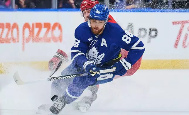Toronto Maple Leafs' William Nylander (88) battles for the puck with Carolina Hurricanes' Jaccob Slavin (74) during first-period NHL hockey game action in Toronto, Friday, March 20, 2026. (Sammy Kogan/The Canadian Press via AP)