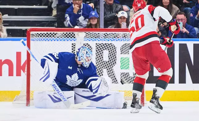 Carolina Hurricanes' Eric Robinson (50) scores on a penalty shot against Toronto Maple Leafs goaltender Joseph Woll, left, during second-period NHL hockey game action in Toronto, Friday, March 20, 2026. (Sammy Kogan/The Canadian Press via AP)